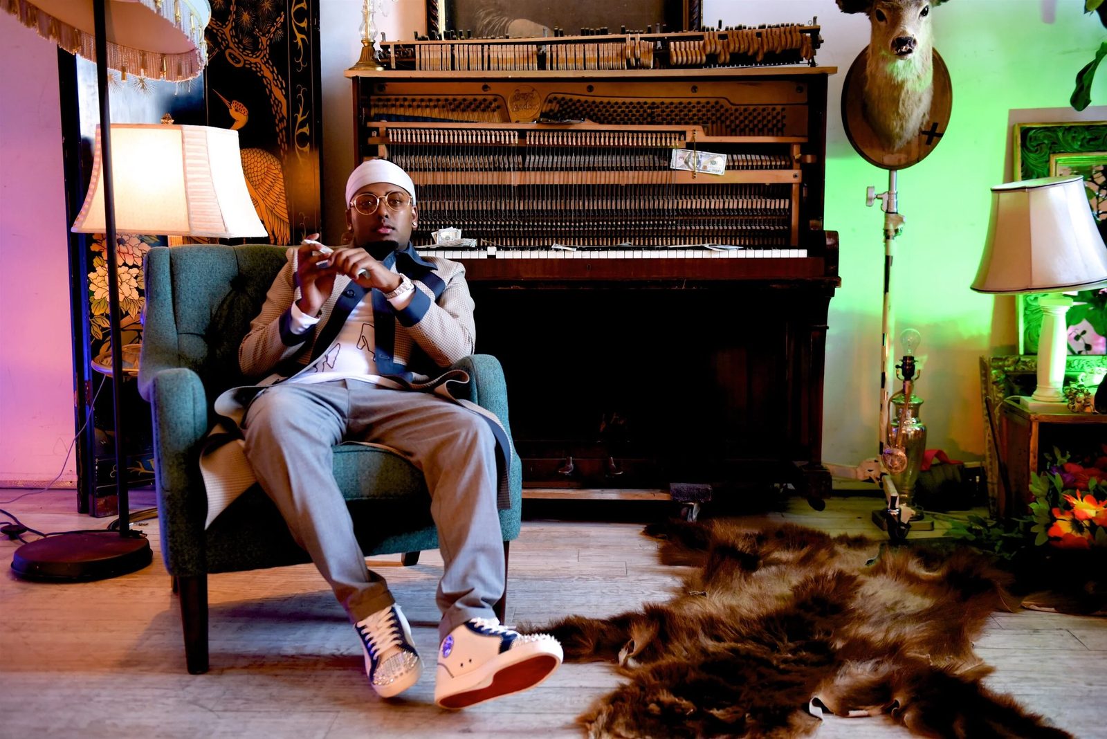 DJ SpinKing seated by an open upright piano
